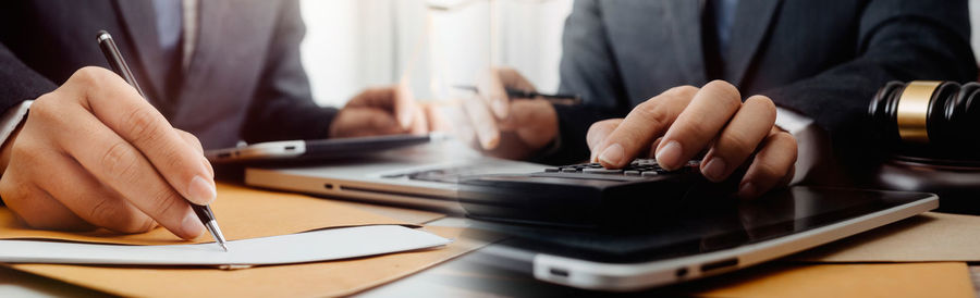 Close-up of man using laptop on table