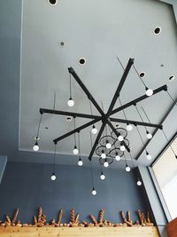 Low angle view of illuminated pendant lights hanging from ceiling