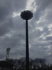 Low angle view of communications tower against cloudy sky