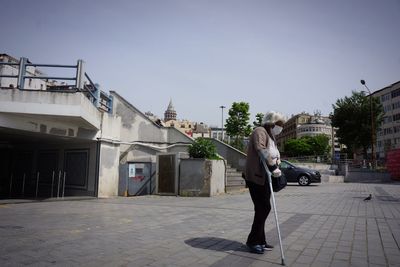 People walking on street amidst buildings in city