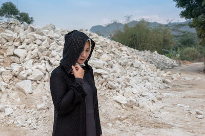 Side view of woman standing on land against sky