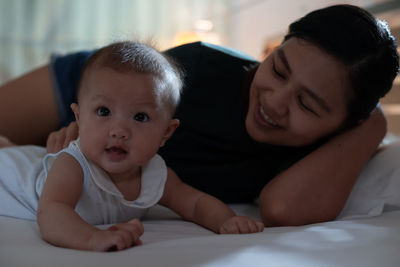 Mother playing with cute girl at home