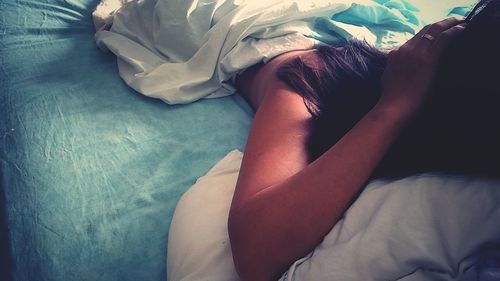 High angle view of woman sleeping on bed