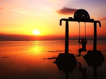 Silhouette people on beach against sky during sunset