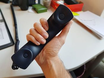 Close-up of man holding telephone receiver