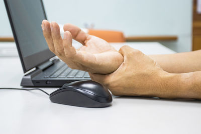 Midsection of man using laptop on table