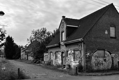 Old building by road against sky