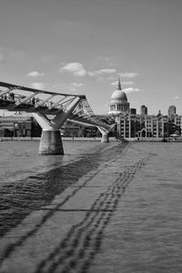 Bridge over river against buildings in city