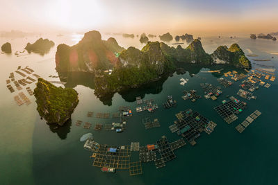 Aerial view of built structure in sea during sunset