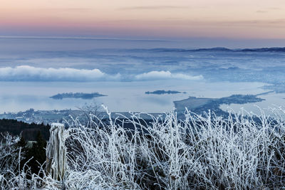 Scenic view of snow covered landscape against sky during sunset