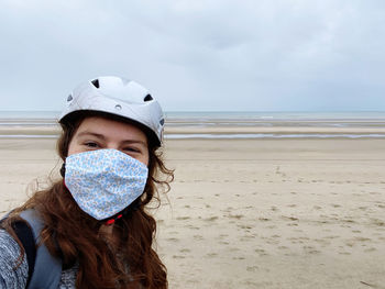 Portrait of woman on beach against sky