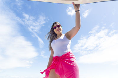 A woman on top of a boat against the sea in the background. 