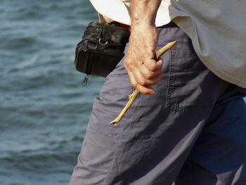 Midsection of man holding smart phone