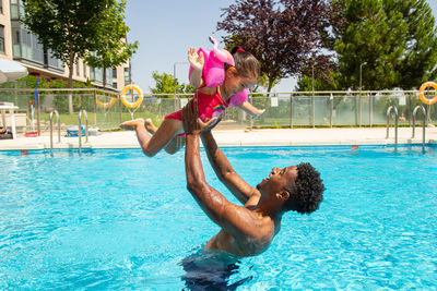 Father and daughter having fun in pool