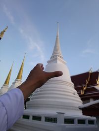 Low angle view of hands against building