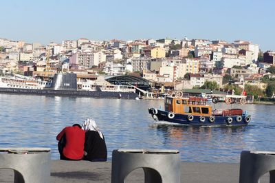 Boats in river with buildings in background