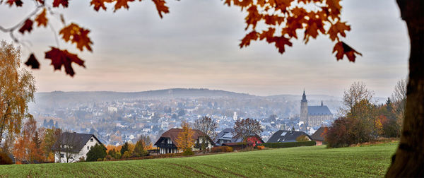 Panoramic view of trees and buildings against sky