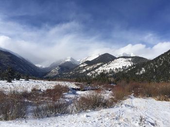 Snow covered mountains against cloudy sky