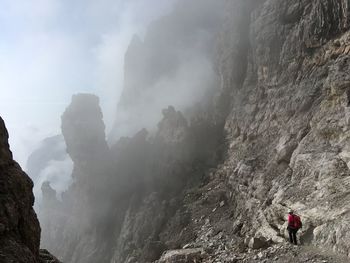 Rear view of people on rocks against mountains