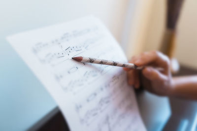 Close-up of hand holding pencil on paper