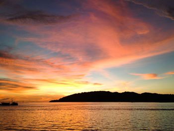 Scenic view of sea against dramatic sky during sunset