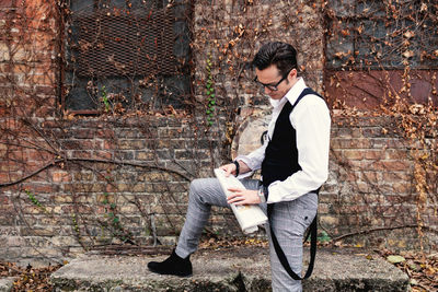 Mid adult man reading newspaper outdoors.