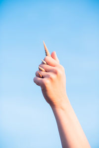 Midsection of person holding hands against clear sky