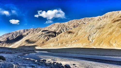 Scenic view of mountains against blue sky