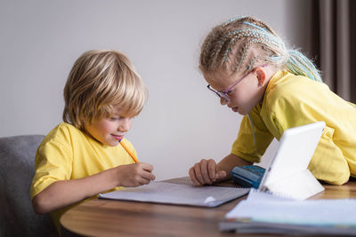 Side view of boy drawing on table