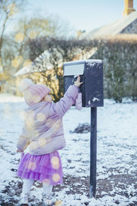 Charming baby throws a letter in the mailbox