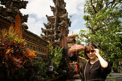 Portrait of woman by temple against building