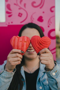 Mexican woman plays with two heart-shaped bread shells