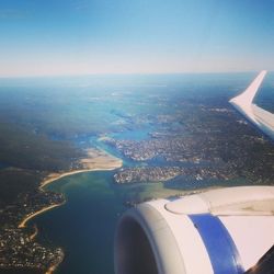 Cropped image of airplane wing over landscape