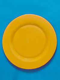 High angle view of yellow juice against blue background