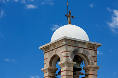 Low angle view of church bell tower against blue sky