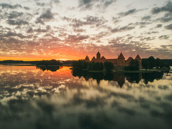 Reflection of buildings in lake during sunset