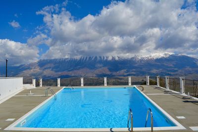 View of swimming pool against cloudy sky