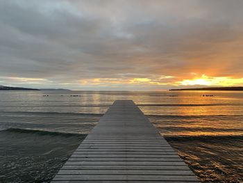 Pier over sea against sky during sunset