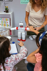 Student putting a piece in recycled toy robot made with plastic packages