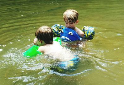 Shirtless boys swimming in lake