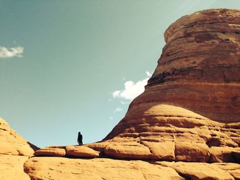 Man standing on cliff against sky