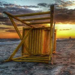 Scenic view of sea against cloudy sky at sunset