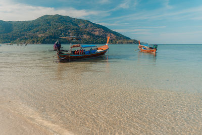 Boats in sea against sky