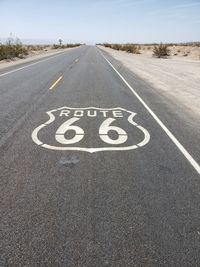 Route 66 sign on empty highway