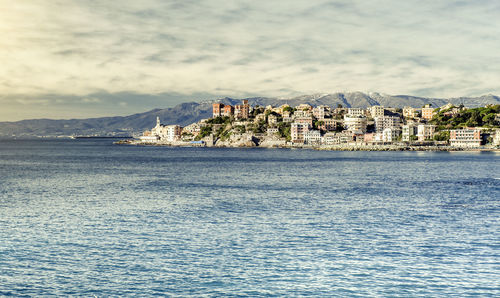 View of houses in town against cloudy sky