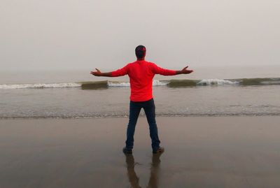 Full length rear view of man standing on beach