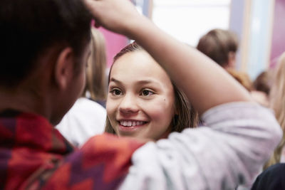 Smiling girl looking at female friend in middle school