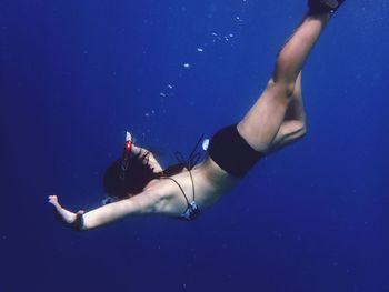 Low section of man swimming in pool