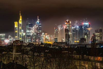 Illuminated buildings in city against sky at night