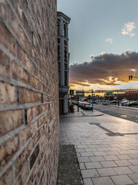 Street by buildings against sky during sunset